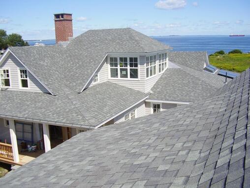 Finished gray roofing with ocean landscape in background