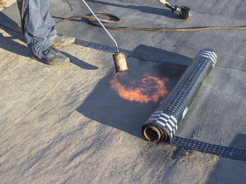 Contractor heating rubber roofing for flat roof